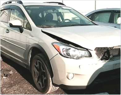 White SUV with front damage parked outdoors in a lot