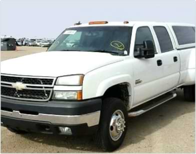 Dark gray BMW with front and side damage parked outdoors in a lot